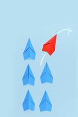 Red paper airplane changing course while leading blue airplanes. Concept for leadership, discovery...