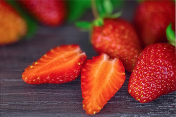 ripe strawberry berries on a wooden background macro. background with ripe fresh strawberries. whole strawberries and strawberry halves close-up.