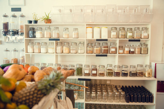 Eco-friendly zero waste shop interior. Dispensers for cereals, nuts and grains in sustainable plastic free grocery store. Bio organic food. Shopping at small local businesses