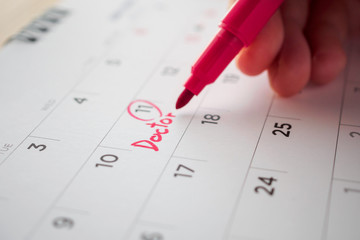 important doctor appointment schedule write on white calendar page date close up