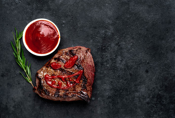 Grilled beef monster steak with spices for halloween on stone background