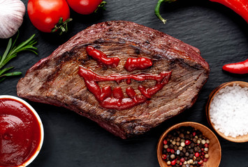 Grilled beef monster steak with spices for halloween on stone background