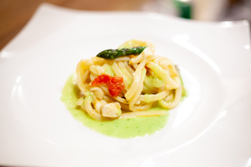 Fettuccine fatte in casa con salsa di olio e basilico, pomodorini, pesce spada e asparagi croccanti.