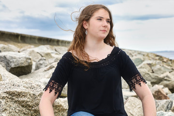 Young Model Sitting On Rocks