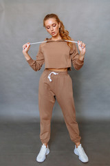 Girl model in a tracksuit. Clothing demonstration in the Studio