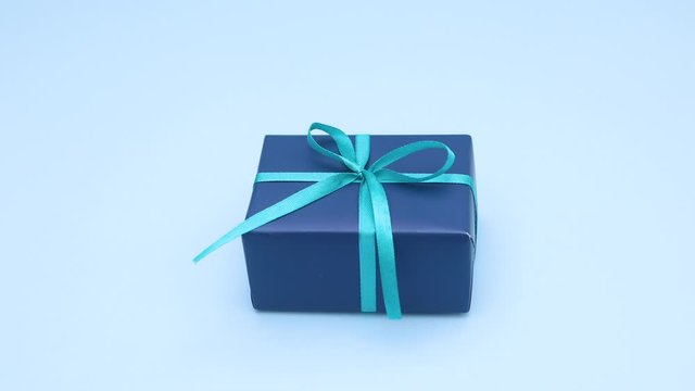 Looping stop motion animation of blue gift moving on blue theme