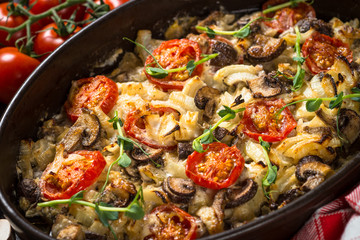 Baked meat with vegetables on black table.