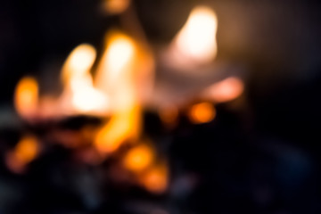 Abstract background of burning fire glow bokeh in indoor home interior fireplace with closeup of orange, blue flame