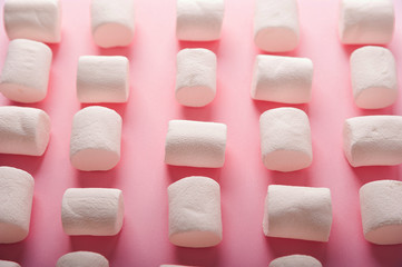 Marshmallows on a pink background close up and copy space. Marshmallow pattern top view on pink background.