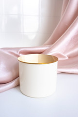 beige podium topper with gold top on satin background with folds. background tile in the bathroom. Luxurious showcase for advertising and product promotion..