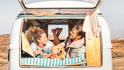 Hipster people with cute dog traveling together on vintage minivan - Wanderlust and life...