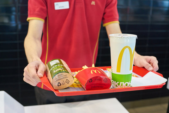 KALININGRAD, RUSSIA - CIRCA SEPTEMBER, 2018: worker with food served on a tray in McDonald's restaurant. McDonald's is an American fast food company.