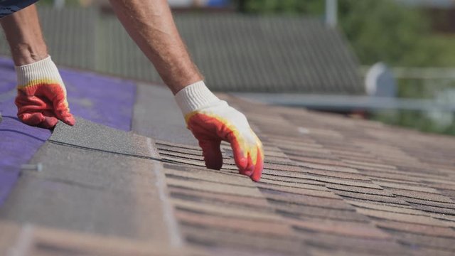 Roofing work. Laying a soft roof on the roof of a private house.