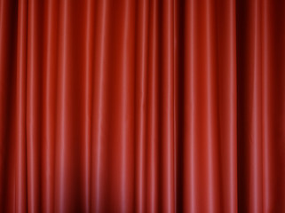 Front view of a folded red polyester curtain. High resolution full frame textured background.