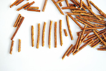 High angle view of a handful of pretzel sticks thrown out on a white underground
