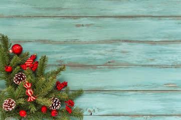 Christmas light blue background, old wood texture, corner decorate. Pine leaf, cones, red golden balls, baubles, berries, candy, gift box. Xmas, New Year wallpaper, greeting card, top view flat lay.