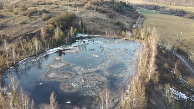 Aerial orbiting view of gudron petrol toxic waste pit during winter season