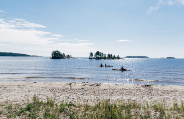 Silhouettes of kayaks at the sandy beach on lake Ladoga on a Sunny summer day