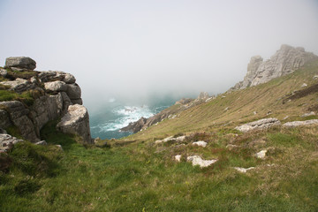 Fototapeta na wymiar The rocky coastline of the island of Lundy emerging from the fog, The Bristol Channel, Devon, UK