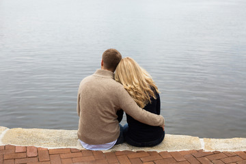 Caucasian couple hugging by lake