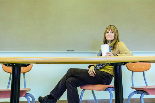 Caucasian professor sitting at table in classroom