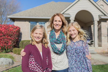 Caucasian mother and daughters smiling in yard