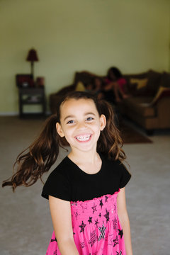 Grinning mixed race girl in living room