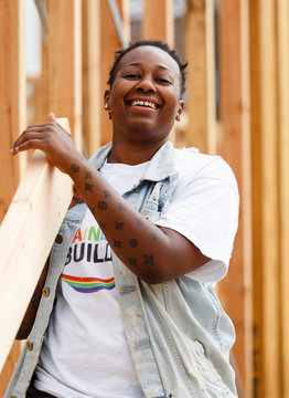 Mix race volunteer carrying lumber at construction site