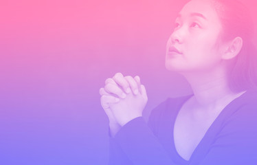 Asian Woman praying and worship to GOD Using hands to pray in religious beliefs and worship christian in the church or in general locations in vintage color tone or copy space.