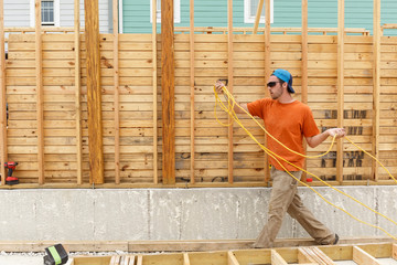 Caucasian man carrying wire at construction site
