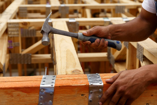 Mixed race man hammering nail at construction site