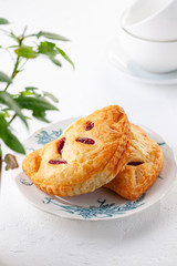 two puff buns with raspberries on a vintage plate on a white background close-up.
