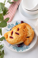 two puff buns with raspberries on a vintage plate on a white background close-up.