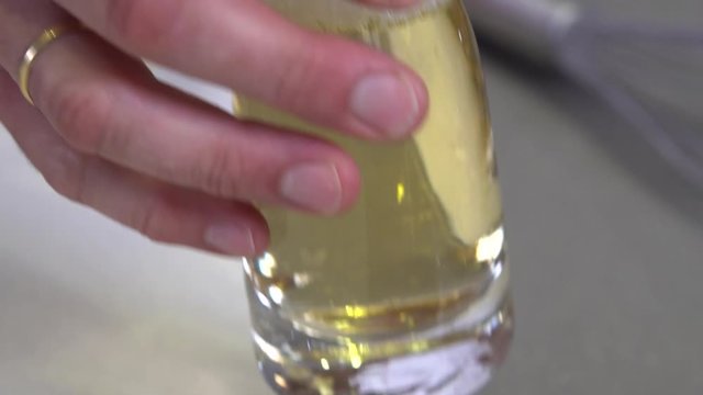 Pouring white wine into glass bowl mixing with other ingredients