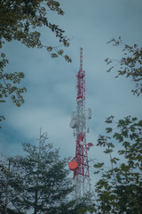 Obraz premium Big antenna mast for 3G, 4G and 5G repeater in the middle of the forest or nature. Controversial tehnology in the wild nature. Panoramic view.