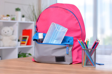 Backpack with school supplies and sanitizer and medical protective mask.Back to school and kindergarten after coronavirus. the beginning of the school season.Virus and disease prevention for kids.