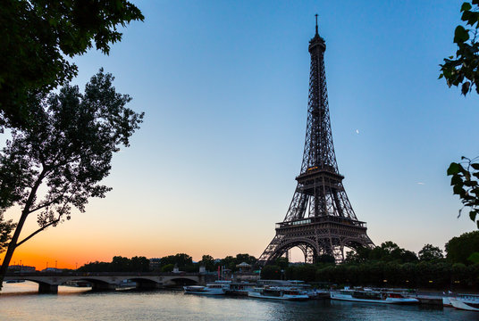 Eiffel Tower by seine river against clear sky at sunset, Paris, France