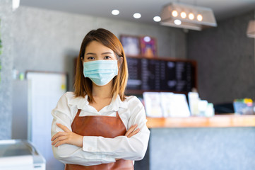 New normal startup small business Portrait of Asian woman barista wearing protection mask and face...