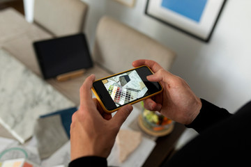 Architect taking photograph of color swatch at home office