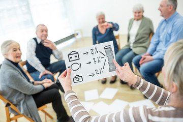 Person holding sheet with cost calculation for gereatric care in retirement home