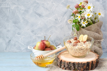 Oatmeal with nuts and honey in a glass transparent bowl with a copy of the space