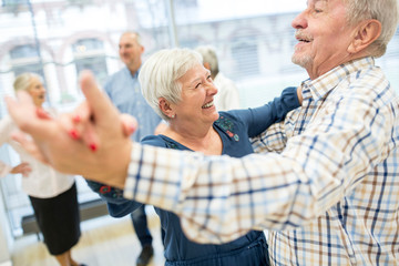Group of active senior attending dance course in retirement home