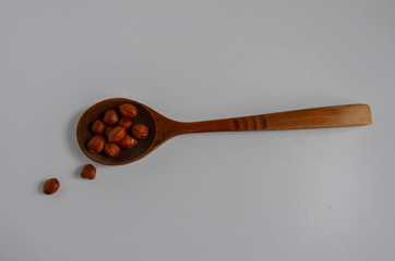 Hazelnuts  and spoon on a white background. 