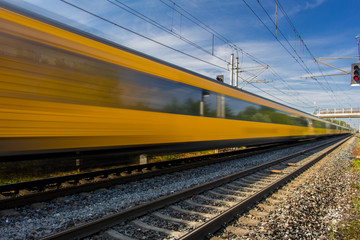 Fototapeta premium Train in movement by rail with a blue sky
