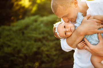 Loving father with adorable baby girl at the park, young parent hold cute toddler in arms, smiling,...