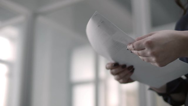 person gives papers to woman and shakes hands with colleague