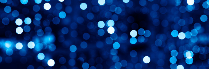 blurred glowing lights of garlands of classic blue color, bokeh. banner