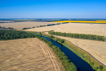 Fototapeta na wymiar aerial photography of a bend in a river flowing through mown fields