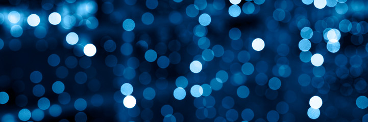 blurred glowing lights of garlands of classic blue color, bokeh. banner