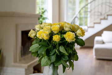 Bouquet of yellow roses on the background of the living room interior